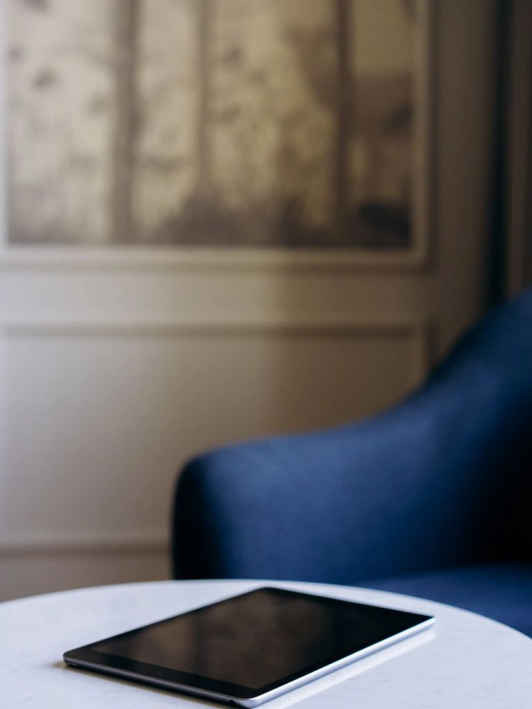 A tablet on a kitchen table showing four family profile avatars